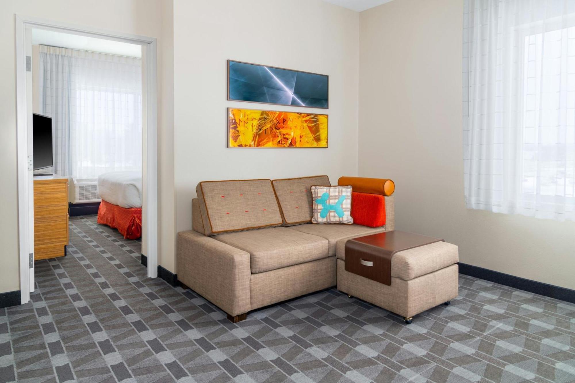 One bedroom suite with a queen bed, sofa bed and couryard view